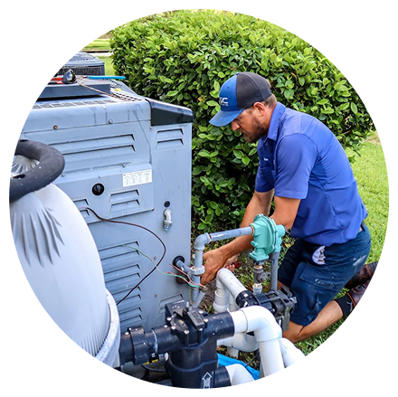 A Hawkins Service Co. technician in a blue uniform and cap repairing pool equipment next to a large gray pool heater and green hedge.